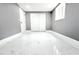 Bedroom with white tile floors, window, and closet featuring bi-fold doors at 9200 Lunar Ln, Port Richey, FL 34668