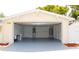 Open garage showing gray painted floor, water heater, HVAC system, and exterior door at 9200 Lunar Ln, Port Richey, FL 34668