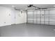 Clean garage features a gray painted floor, garage door opener, and exterior door at 9200 Lunar Ln, Port Richey, FL 34668