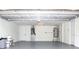 Clean garage features a gray painted floor, water heater, and HVAC system at 9200 Lunar Ln, Port Richey, FL 34668