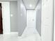 Hallway with white tile floors, modern lighting, and access to adjacent rooms at 9200 Lunar Ln, Port Richey, FL 34668