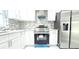 Close-up of a kitchen featuring stainless steel appliances and modern white cabinetry at 9200 Lunar Ln, Port Richey, FL 34668