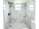 Modern shower featuring elegant marble tiling, contemporary fixtures and a rainfall shower head at 9200 Lunar Ln, Port Richey, FL 34668