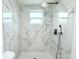 Modern shower featuring elegant marble tiling, contemporary fixtures and a rainfall shower head at 9200 Lunar Ln, Port Richey, FL 34668