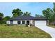 Charming single-story home featuring stone accents, a well-manicured lawn, and a two-car garage at 9482 Noddy Tern Rd, Weeki Wachee, FL 34613