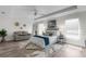 Spacious primary bedroom with a tray ceiling, neutral paint, wood-look floors, and contemporary furnishings at 9482 Noddy Tern Rd, Weeki Wachee, FL 34613