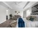 Spacious primary bedroom with a tray ceiling, neutral paint, wood-look floors, and comfortable seating area at 9482 Noddy Tern Rd, Weeki Wachee, FL 34613