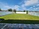 The large backyard features a well-maintained lawn and a white fence perimeter at 954 Old Windsor Way, Spring Hill, FL 34609