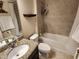 This bathroom offers a granite counter top, shower with a tub, and tiled walls at 954 Old Windsor Way, Spring Hill, FL 34609