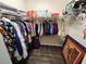 Walk-in closet with wood floors is well-organized with hanging clothes and shelving at 954 Old Windsor Way, Spring Hill, FL 34609