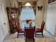 Charming dining area with a glass-top table, red chairs, decorative accents, and a built-in display cabinet at 954 Old Windsor Way, Spring Hill, FL 34609