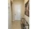 The hallway boasts a decorative table with a lamp next to a white front door at 954 Old Windsor Way, Spring Hill, FL 34609