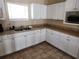 Kitchenette with stainless steel sink, tan countertops, and white cabinets at 954 Old Windsor Way, Spring Hill, FL 34609
