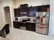 Well-equipped kitchen featuring stainless steel appliances, dark wood cabinets, and granite countertops at 954 Old Windsor Way, Spring Hill, FL 34609
