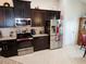 Modern kitchen featuring stainless steel appliances, dark cabinetry, and a tile backsplash at 954 Old Windsor Way, Spring Hill, FL 34609