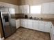 Kitchenette featuring stainless steel fridge, light countertops, and white cabinets at 954 Old Windsor Way, Spring Hill, FL 34609