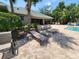 Relaxing poolside lounge area with comfortable chairs, greenery, and shade trees at 954 Old Windsor Way, Spring Hill, FL 34609