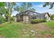 Backyard with screened-in pool and beautiful lawn and landscaping at 9757 Hermosillo Dr, New Port Richey, FL 34655