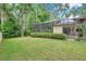 Large backyard with lush green grass and a screened-in pool at 9757 Hermosillo Dr, New Port Richey, FL 34655