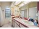 Bright bathroom features double sinks and a shower with white tiling at 9757 Hermosillo Dr, New Port Richey, FL 34655