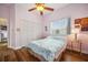 This bedroom has wood floors, a ceiling fan, and a large closet at 9757 Hermosillo Dr, New Port Richey, FL 34655