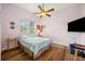 This bedroom has wood floors, a ceiling fan, and a large picture window at 9757 Hermosillo Dr, New Port Richey, FL 34655