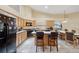 Bright kitchen featuring an island with seating, light wood cabinets and white tile floors at 9757 Hermosillo Dr, New Port Richey, FL 34655