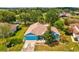 Aerial view of a charming blue house with a well-manicured lawn, surrounded by mature trees at 2255 Long View Cir, Brooksville, FL 34604