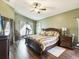 Spacious bedroom with wood floors, a ceiling fan, and large windows with curtains at 2255 Long View Cir, Brooksville, FL 34604