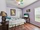 Cozy bedroom with wood floors, a colorful ceiling fan, and ample natural light from the window at 2255 Long View Cir, Brooksville, FL 34604