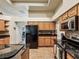 Spacious kitchen featuring wooden cabinets, black appliances, and a view into the dining area at 2255 Long View Cir, Brooksville, FL 34604
