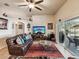 Comfortable living room with a leather sofa, ceiling fan, and sliding glass doors to the patio at 2255 Long View Cir, Brooksville, FL 34604