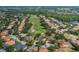 Aerial view of a home in a golf community with large trees and other homes at 10645 Garda Dr, Trinity, FL 34655