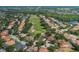 Overhead view of a lovely golf community lined with mature trees and a serene lake at 10645 Garda Dr, Trinity, FL 34655