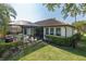 Landscaped backyard of home with screened-in pool, and view of golf course at 10645 Garda Dr, Trinity, FL 34655
