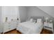 Bright bedroom featuring a bed with tufted headboard, white dresser, and light-filled windows at 10645 Garda Dr, Trinity, FL 34655