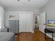 Bedroom with wood floors, gray walls, gray dresser, and an ensuite bathroom visible through the doorway at 10645 Garda Dr, Trinity, FL 34655