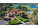Aerial view of the community clubhouse with a pool, red tiled roof, and lush landscaping at 10645 Garda Dr, Trinity, FL 34655
