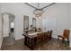 Elegant dining room with wood floors, a rustic wooden table and contemporary lighting, perfect for entertaining guests at 10645 Garda Dr, Trinity, FL 34655