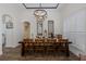 Dining room with a large wooden table with seating for eight, shuttered windows and contemporary light fixture at 10645 Garda Dr, Trinity, FL 34655