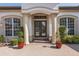 Elegant front entrance with double doors, flanked by columns and manicured greenery, creating a welcoming ambiance at 10645 Garda Dr, Trinity, FL 34655