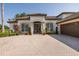 Elegant home exterior with a paver driveway, double doors, and lush landscaping at 10645 Garda Dr, Trinity, FL 34655