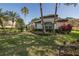 Lush front yard of home showcasing landscaping, shrubbery and mature palm trees at 10645 Garda Dr, Trinity, FL 34655