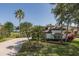 Beautiful home showcasing front lawn, shrubbery and mature palm trees with golf course view at 10645 Garda Dr, Trinity, FL 34655