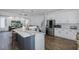 Bright kitchen boasts island with seating, stainless appliances, and seamless flow to living area at 10645 Garda Dr, Trinity, FL 34655