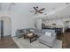 Inviting living room adjacent to kitchen, featuring modern sectional, ceiling fan, and neutral decor at 10645 Garda Dr, Trinity, FL 34655