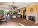 Inviting outdoor kitchen with a built-in grill, bar seating, a cozy fireplace, and a brick-paved floor at 10645 Garda Dr, Trinity, FL 34655