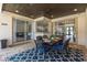 Covered patio with tile flooring and outdoor dining set, providing seamless indoor-outdoor living at 10645 Garda Dr, Trinity, FL 34655