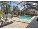 An outdoor pool area provides the perfect opportunity for lounging with a built-in grill at 10645 Garda Dr, Trinity, FL 34655