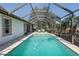 Screened-in pool with turquoise water and outdoor lounge chairs on a sunny day at 10645 Garda Dr, Trinity, FL 34655